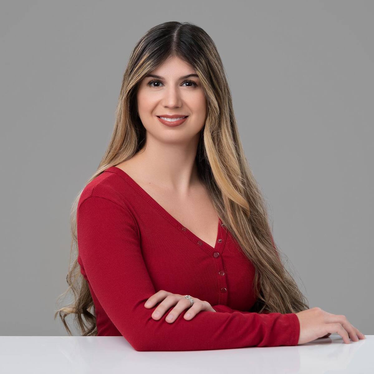 female with long hair and a deep red long sleeved shirt